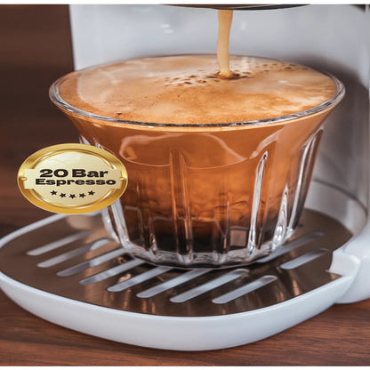 Espresso being poured into a glass with a 20 Bar Espresso badge on a wooden surface.