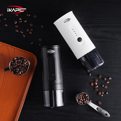 Two coffee grinders, one black and one white, with scattered coffee beans on a dark surface.