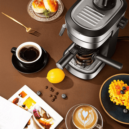 Coffee maker on a table with coffee, lemon, and snacks