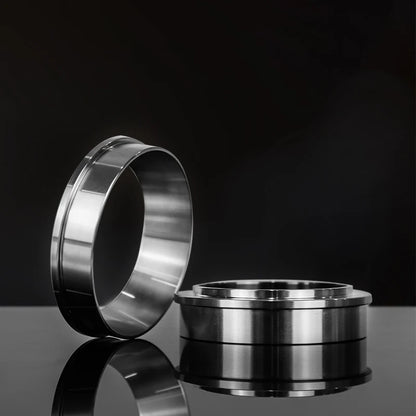 Two metallic rings on a reflective surface with a black background