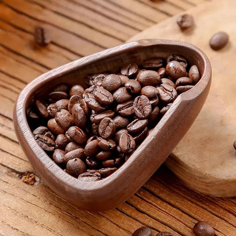 Wooden bowl filled with coffee beans on a wooden surface