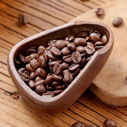 Wooden bowl filled with coffee beans on a wooden surface